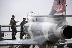 Top Aces A-4 Skyhawk and USAF F-16 pilots discussing ADAIR utility assessment at Spangdahlem Air Base