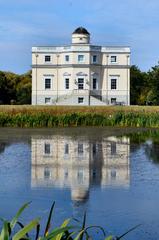 King's Observatory at Kew Gardens viewed from the south across a pond with clear sky