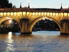 Evening view of the Seine River in Paris with illuminated bridges and reflections on the water