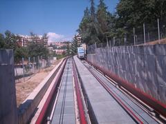 Minimetro electric cabin in motion on suspended monorail in an urban setting