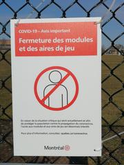 COVID-19 closure notice sign on playground equipment in Montreal