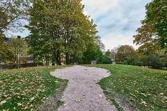 Sinebrychoffin puisto park with lush green trees and benches in Helsinki