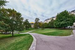 Sinebrychoffin puisto park with lush green trees and paved paths in Helsinki
