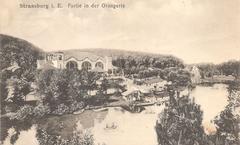 Artificial lake at Parc de l'Orangerie in Strasbourg with former Grand Restaurant building