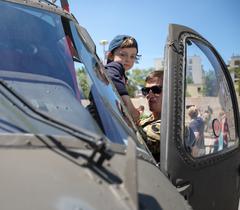 UH-60 Blackhawk helicopter with crew chief Sgt. Henry Davis helping a local child into the pilot seat in downtown Tirana, Albania