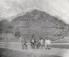 Historic photo of men in front of Maya temple-pyramid mound at Acanceh Yucatan in 1906