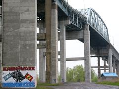 Underneath the Mercier Bridge in Kahnawake showing Kahnawake Ironworkers and Warrior flags