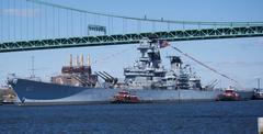 The Battleship USS New Jersey being moved by tugboats down the Delaware River for maintenance