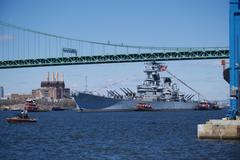 Battleship USS New Jersey BB-62 being moved by tugboats down Delaware River for maintenance
