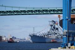 Battleship USS New Jersey being moved by tugboats down the Delaware River for maintenance