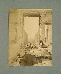Central gate of the Propylaea viewed from the east with fluted columns and two traditional dressed figures