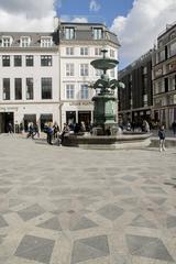 Copenhagen city street with people and historic architecture near a fountain