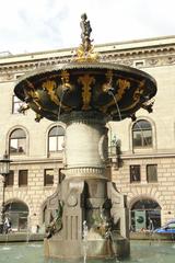 Caritas Well fountain in Copenhagen Denmark with intricate sculptures and flowing water under a blue sky