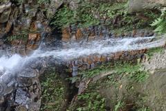 Himchari Fountain with lush green hill in the background