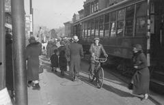 Intersection of Bleury and Ste-Catherine Streets in Montreal with pedestrians, tram, cyclist, and horse-drawn cart