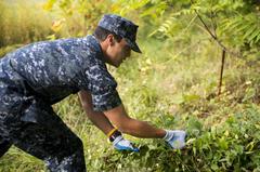 Seaman Avery Smith from USS Oak Hill pulling weeds at Carroll Park during Star-Spangled Spectacular in Baltimore