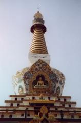 Salugara Stupa in India surrounded by trees under a clear sky