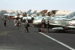 USAF personnel inspecting Egyptian aircraft including MiG-17, MiG-21, Mirage 5SDE, F-4E Phantom II, F-16A Fighting Falcon, and US Navy F-14 Tomcat at Cairo West Air Base during Exercise BRIGHT STAR '83