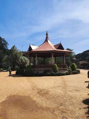 Front view of Napier Museum showing traditional Kerala architecture with lush greenery and people walking