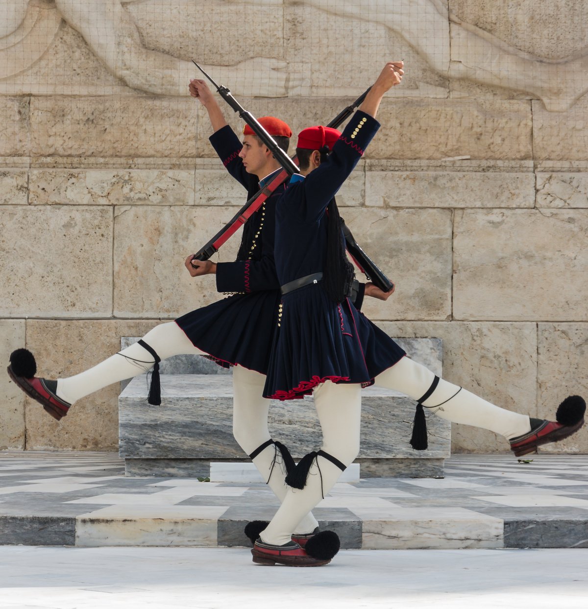 Two Evzones of the Greek Army crossing in front of the Tomb of the Unknown Soldier in Athens, Greece