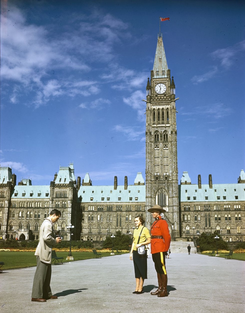 RCMP officer posing in front of Parliament Buildings in Ottawa