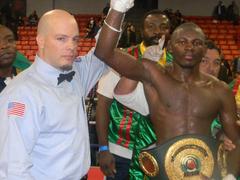 Referee raising hand of Osumanu Adama after winning IBO middleweight championship