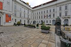 Josefsplatz square in Vienna with historic buildings and statues under a blue sky
