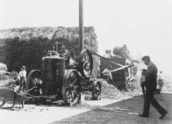 Vintage steam-powered Locomobile threshing scene