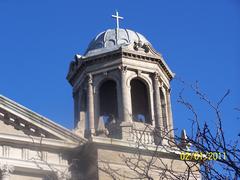 St. Hedwig Church steeple in Chicago with a cross on top against blue sky