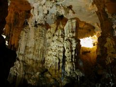 Cave interior in Ha Long Bay with rocky formations and sunlight filtering through