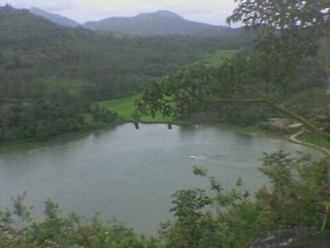 Honnamana Kere lake in Karnataka, India surrounded by lush greenery and hills