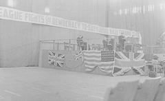 Reverend J. Ostermann speaking at an anti-Nazi rally with a banner and various country flags on the stage