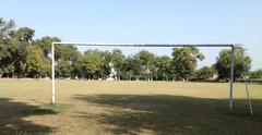 Football ground at Islamia College with green grass and buildings in the background