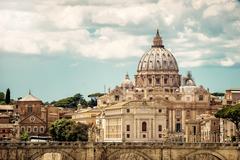 Baroque dome of St. Peter's Basilica in Vatican City with intricate architectural details against a blue sky