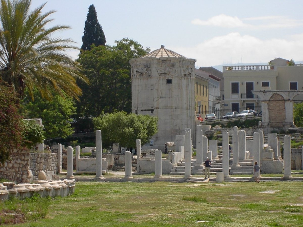 The Agora archaeological site in Athens with ancient Greek ruins and columns under a clear blue sky