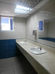 Public men's toilet at Havana airport with blue tiled walls and white toilet cubicles