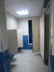 Male public toilet at Havana airport with multiple urinals and blue partitions