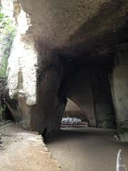 Ancient stone quarry Latomie dei Cappuccini in Siracusa with historic rock formations and greenery