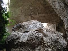 Ancient stone quarries Latomie dei Cappuccini in Syracuse with rugged rock formations and greenery