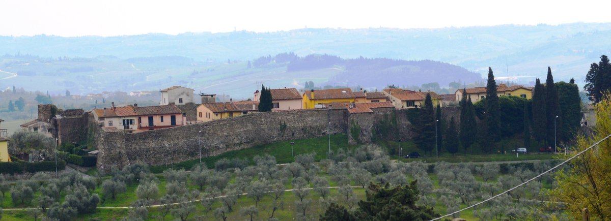 Walls of Malmantile in Florence Italy with green vegetation and blue sky