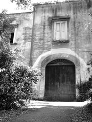 Large wooden door of an abandoned farmhouse in the Capodimonte Forest Naples