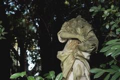 Stone sculpture in greenery near Porta di Mezzo entrance to park