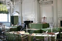 Historic assembly room in Independence Hall with wooden chairs and green baize-covered tables