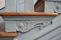 Side view of scroll and leaf brackets underneath a stair tread at Independence Hall staircase
