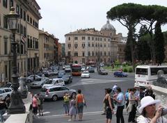 Typical street view in central Rome with painted buildings, traffic, tourists, Umbrella pines, Piazza Aracoeli, a fountain, and a domed church