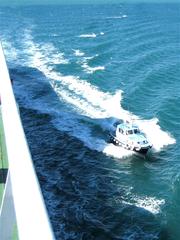 Pilot boat veering off from ferry Ionian Sky after pilot transfer in Brindisi harbor Italy