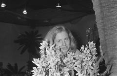 Young girl holding an orchid at the International Orchid Exhibition at the Royal Tropical Institute in Amsterdam on March 4, 1971