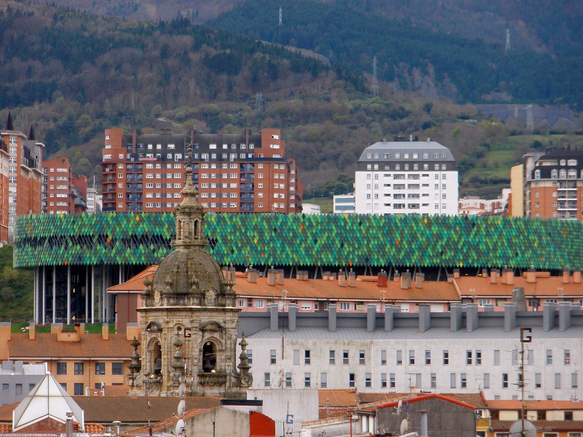 Panoramic view of Bilbao from the Solokoetxe neighborhood with city buildings and green hills in the background