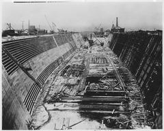 Historical black and white photograph showing construction progress of Hunters' Point Dry Dock in San Francisco around 1868