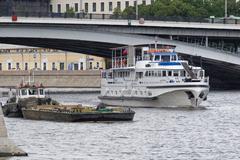 Moscow Jupiter tugboat with barge on the water
